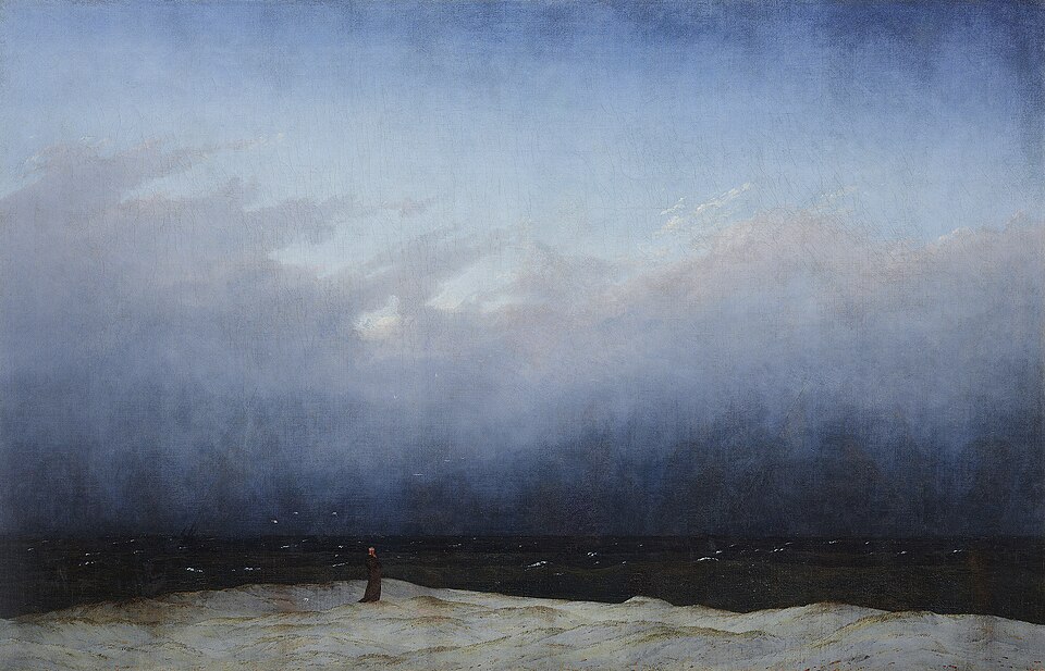 Une minuscule silhouette de moine sur une grève, face à une mer sombre sous un ciel immense