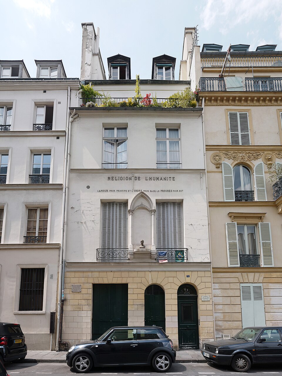 Façade du temple de l'Humanité, rue Payenne, avec un buste et une inscription